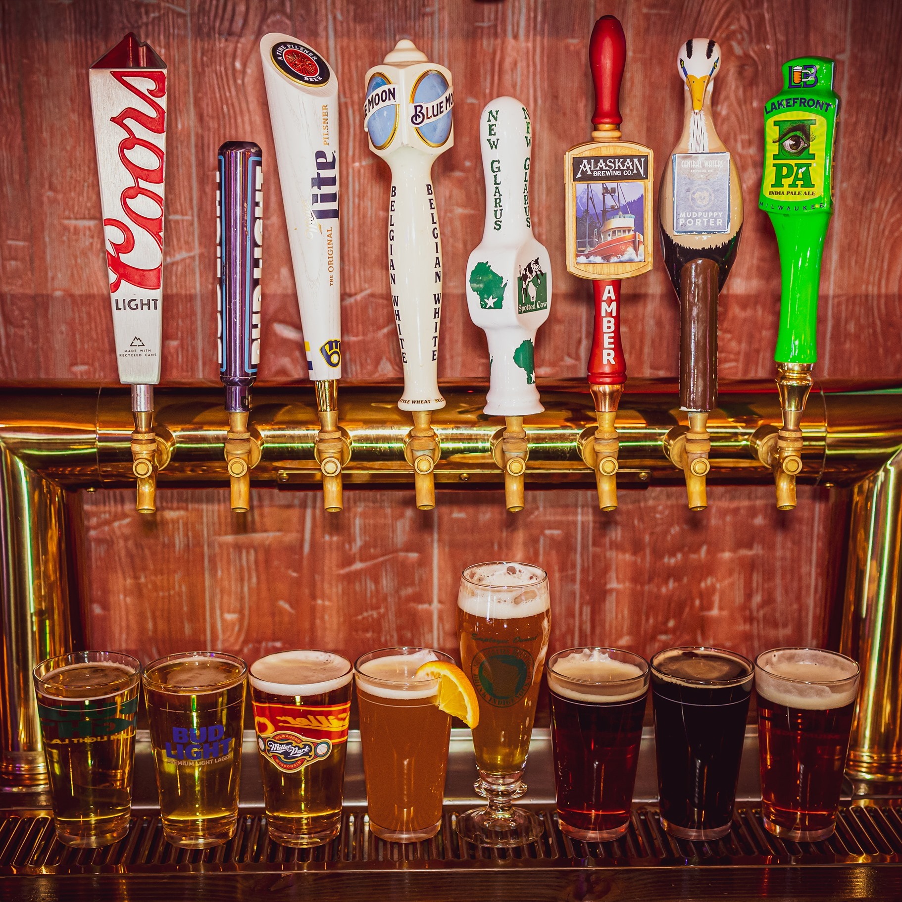 Eight beer taps and poured glasses at the Tavern on Rock bar